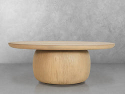 A round wooden table crafted from natural wood, showcasing its organic texture and warm tones